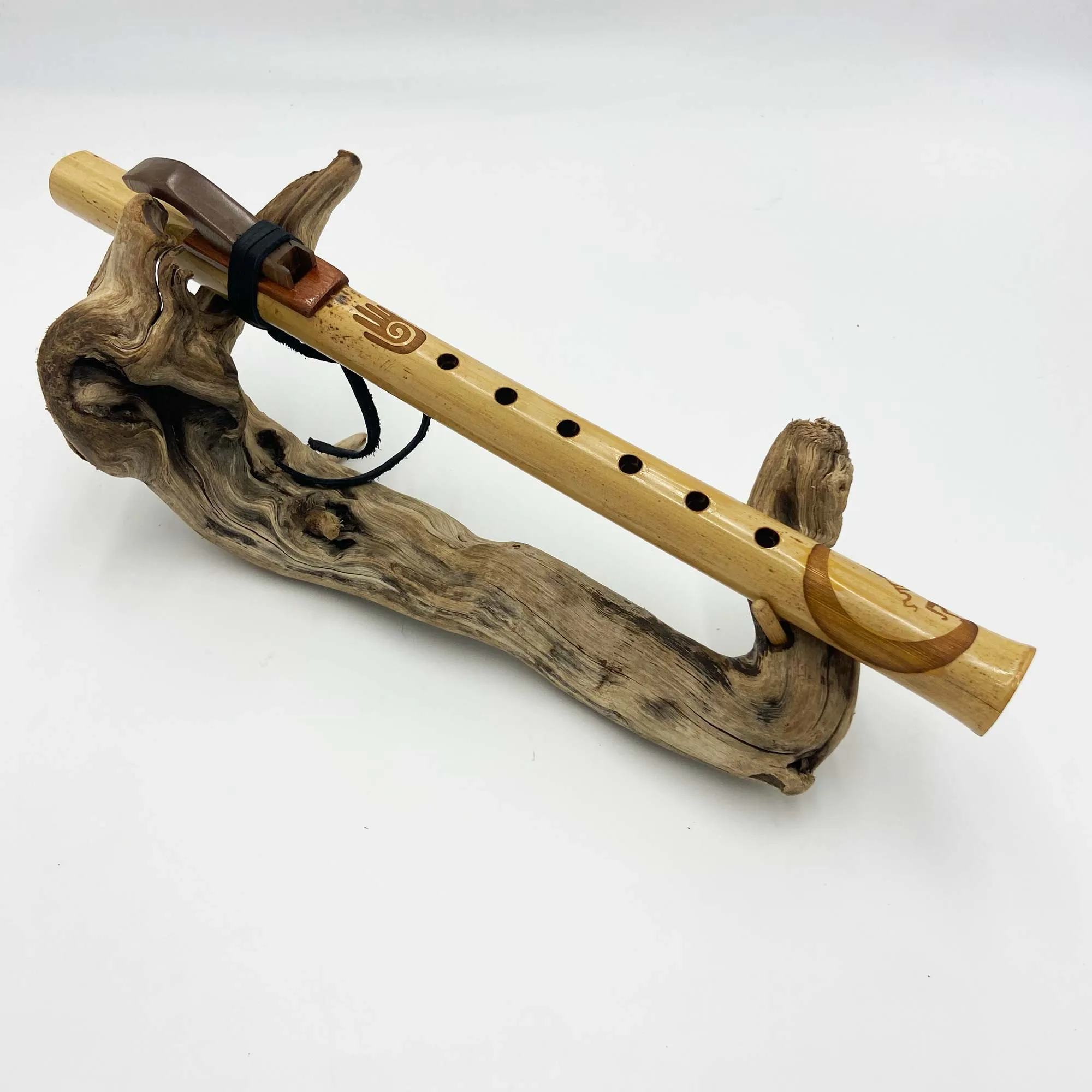 Gros plan sur l'embouchure et la fixation du bec d'une flûte amérindienne artisanale, ruban d'attache visible sur le côté